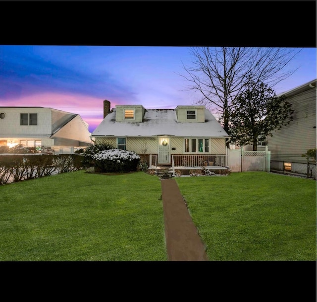 back house at dusk featuring a yard