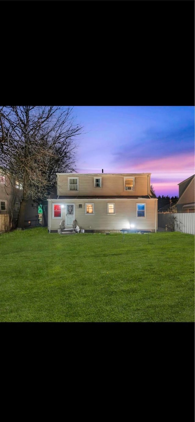 back house at dusk with a yard