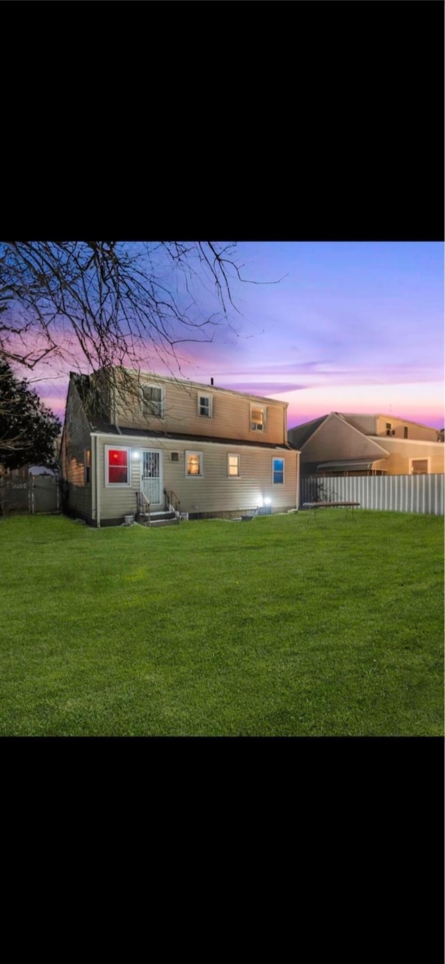 back house at dusk with a yard