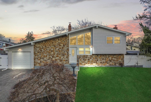 view of front of home featuring a garage and a lawn