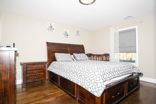 bedroom with dark hardwood / wood-style floors