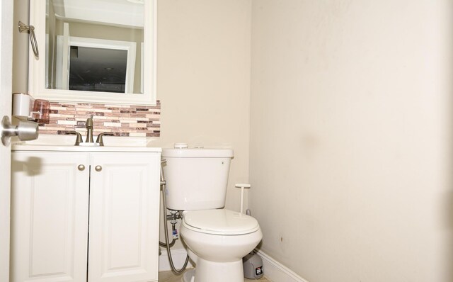 bathroom featuring tasteful backsplash, vanity, and toilet