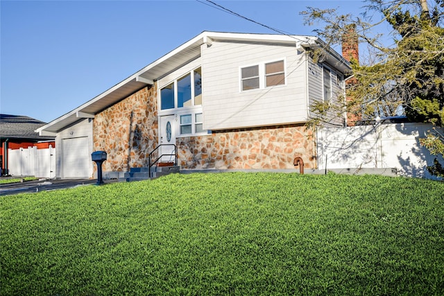 view of side of home featuring a garage and a lawn