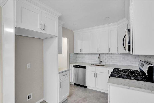 kitchen with sink, appliances with stainless steel finishes, backsplash, light stone countertops, and white cabinets