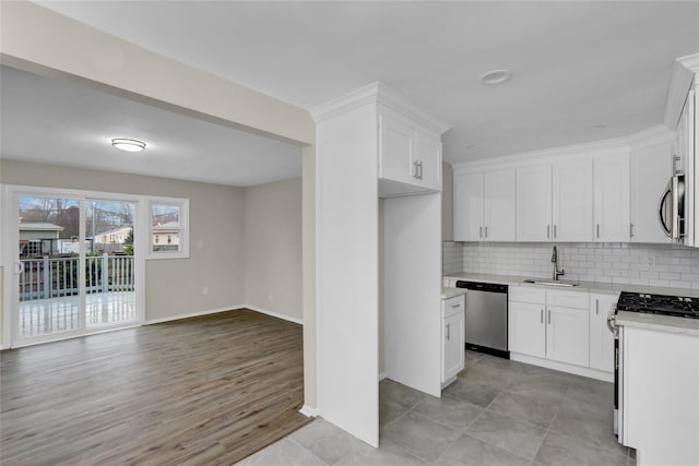 kitchen featuring tasteful backsplash, appliances with stainless steel finishes, sink, and white cabinets