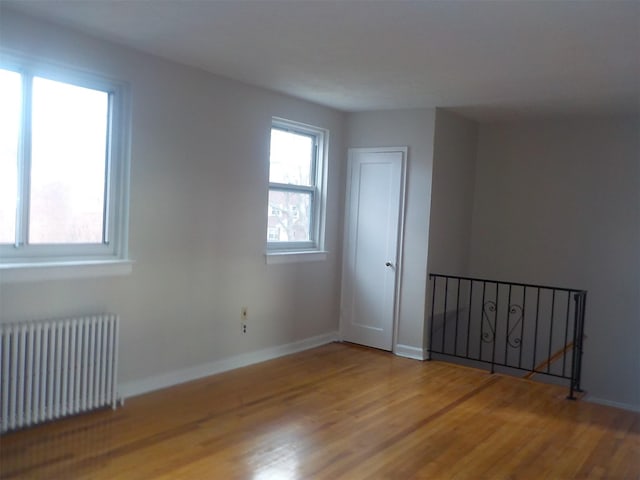 unfurnished room featuring wood-type flooring and radiator