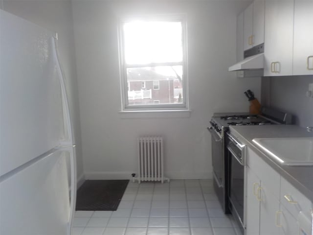 washroom with radiator, sink, and light tile patterned flooring