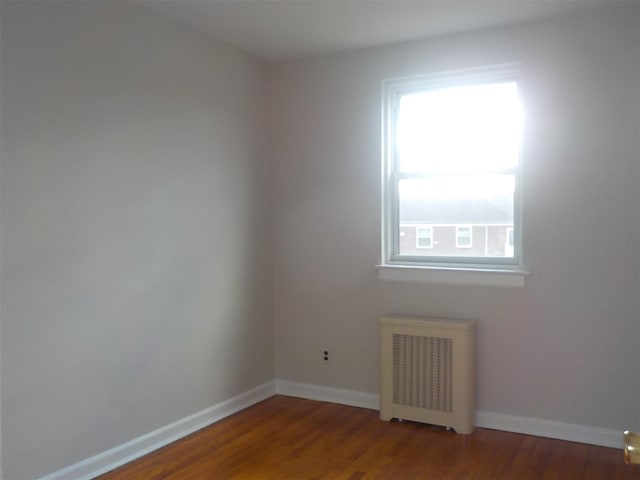 spare room with hardwood / wood-style flooring and radiator