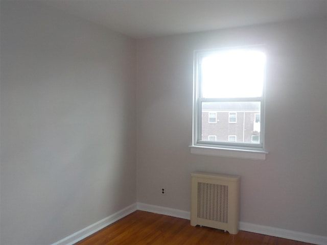 unfurnished room with radiator and hardwood / wood-style floors