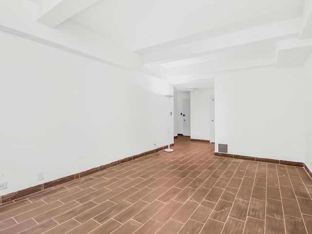 unfurnished room featuring dark wood-type flooring and beam ceiling