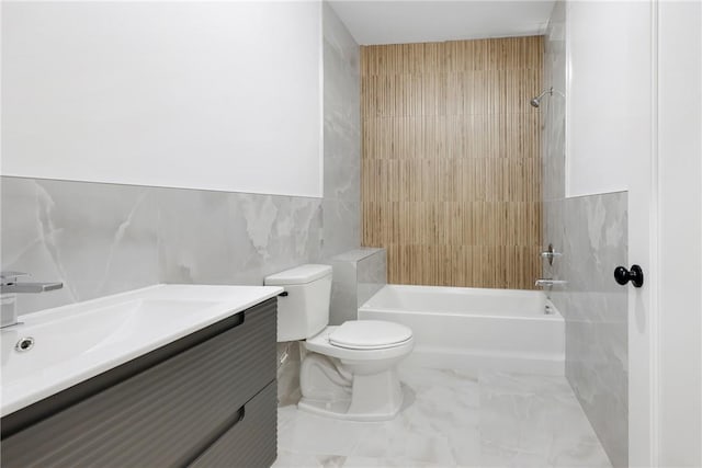 full bathroom featuring tile walls, vanity, tiled shower / bath combo, and toilet