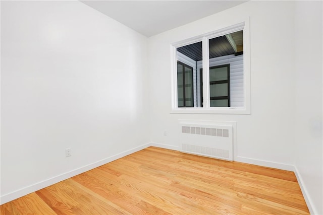 unfurnished room with wood-type flooring and radiator heating unit