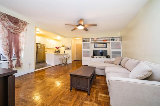 living room with ceiling fan and dark parquet floors