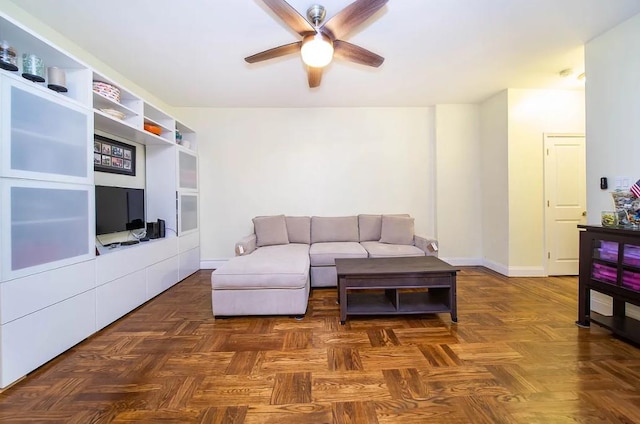 living room with dark parquet flooring and ceiling fan