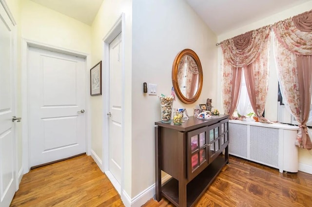 hallway featuring hardwood / wood-style flooring and radiator