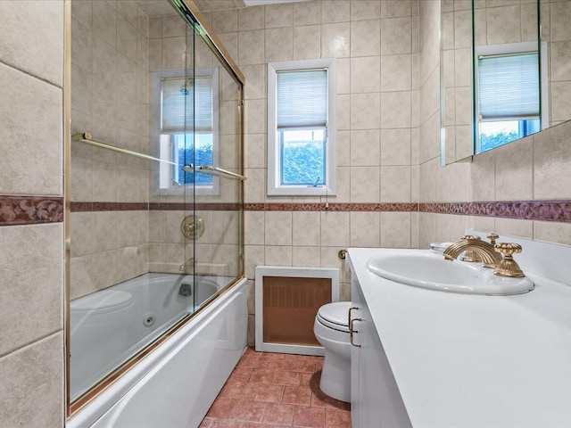 80-51 Little Neck Pkwy, Glen Oaks, NY 11004 - full bathroom with tile walls, toilet, plenty of natural light, vanity, and bath / shower combo with glass door