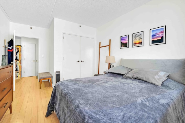 bedroom featuring light hardwood / wood-style floors, a closet, and a textured ceiling