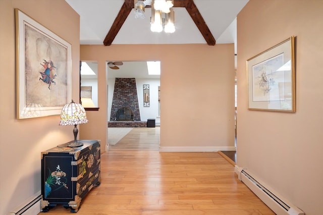 hall featuring beamed ceiling, a baseboard heating unit, and light wood-type flooring