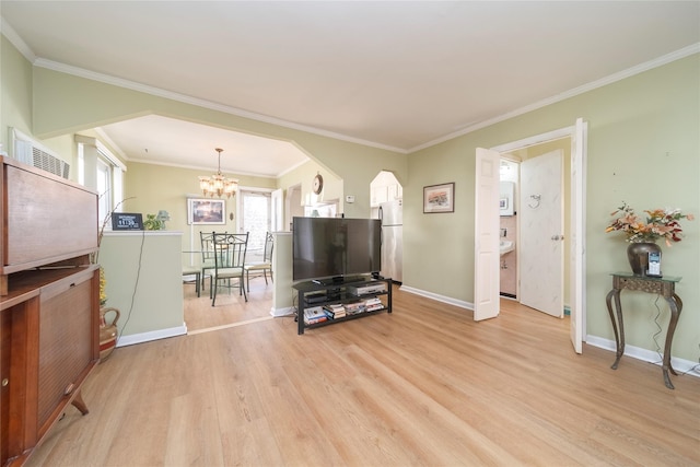 living room featuring crown molding, a chandelier, and light wood-type flooring