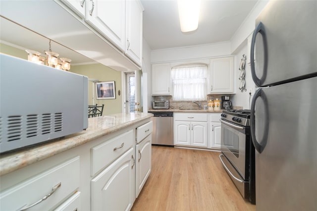 kitchen featuring sink, white cabinets, decorative backsplash, light hardwood / wood-style floors, and stainless steel appliances