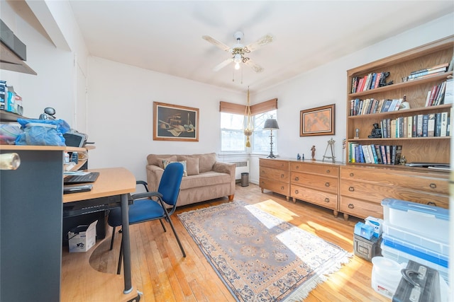 office featuring radiator, hardwood / wood-style flooring, and ceiling fan