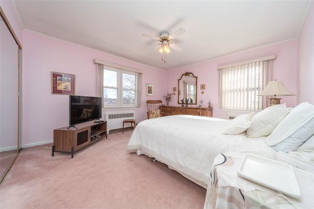 carpeted bedroom featuring multiple windows, radiator, a closet, and ceiling fan