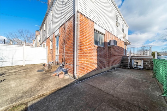 view of home's exterior featuring a patio and a wall mounted AC