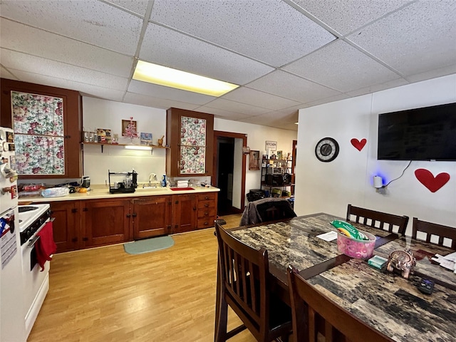 kitchen featuring sink, white electric range oven, a drop ceiling, and light hardwood / wood-style floors
