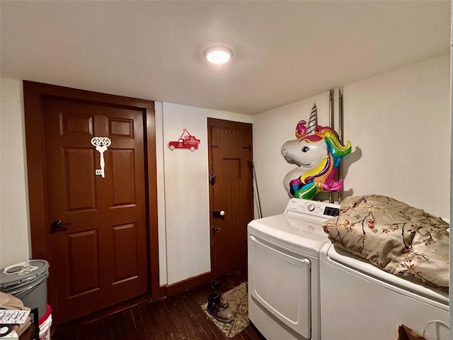 clothes washing area featuring dark wood-type flooring and washer and clothes dryer