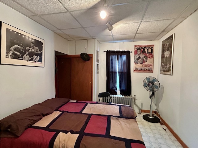 bedroom featuring a drop ceiling and radiator