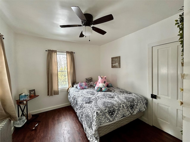 bedroom with ceiling fan, radiator, and dark hardwood / wood-style floors