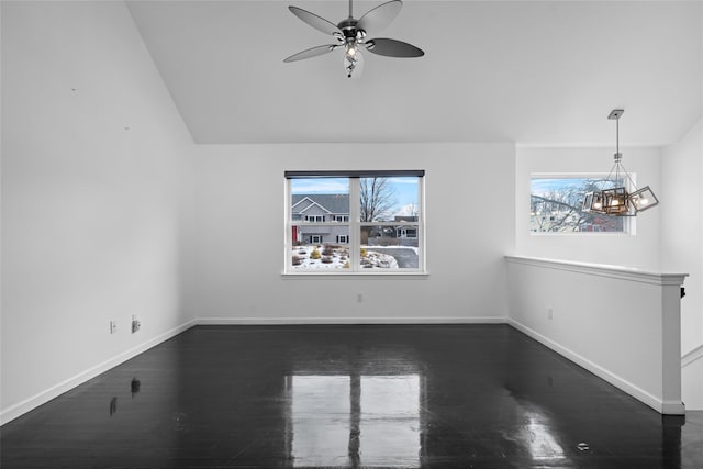 unfurnished living room featuring lofted ceiling, dark hardwood / wood-style floors, and ceiling fan with notable chandelier