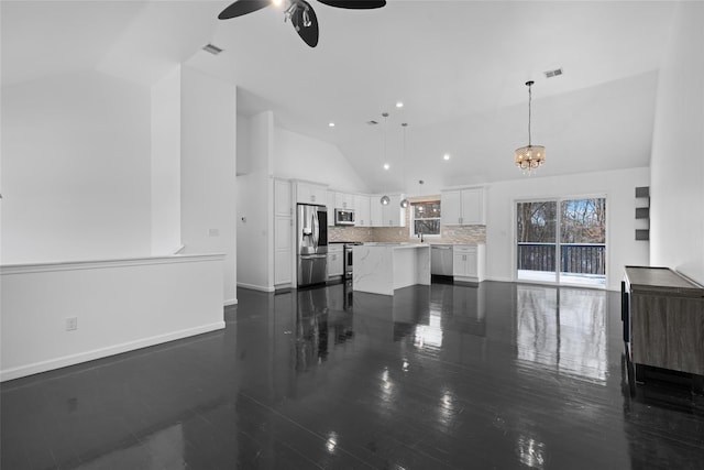 living room featuring lofted ceiling and ceiling fan with notable chandelier