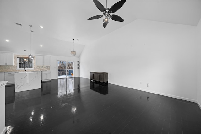 unfurnished living room featuring dark wood-type flooring, ceiling fan, lofted ceiling, and sink