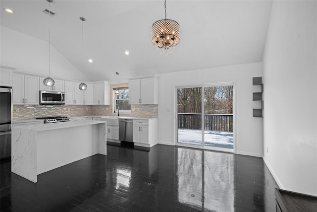 kitchen featuring white cabinetry, stainless steel appliances, and hanging light fixtures