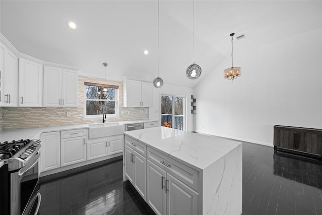 kitchen with a kitchen island, sink, white cabinets, and appliances with stainless steel finishes