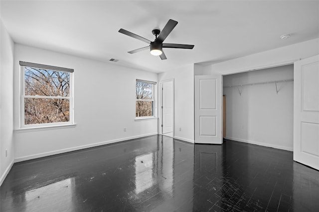 unfurnished bedroom with dark hardwood / wood-style floors, ceiling fan, and a closet