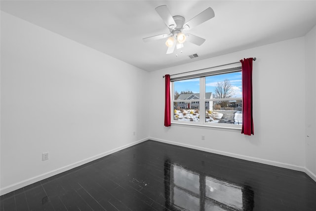 empty room featuring dark wood-type flooring and ceiling fan