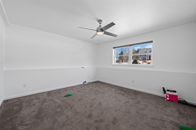 spare room featuring dark colored carpet and ceiling fan