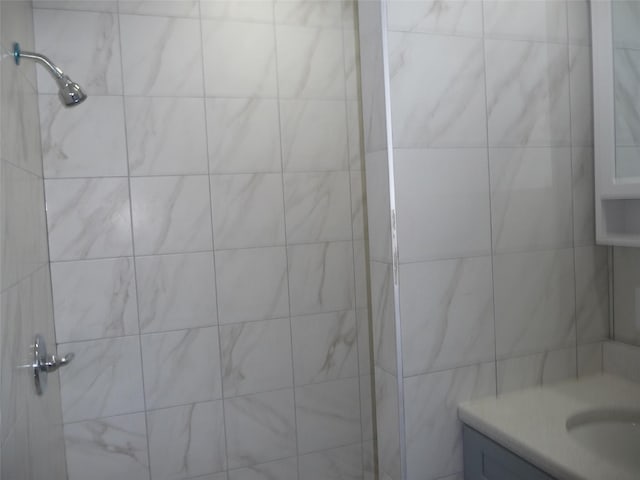 bathroom with vanity and a tile shower