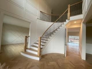 stairway featuring a high ceiling and parquet floors