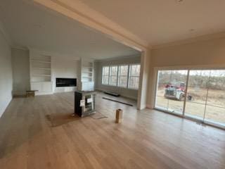 unfurnished living room with crown molding and light hardwood / wood-style floors