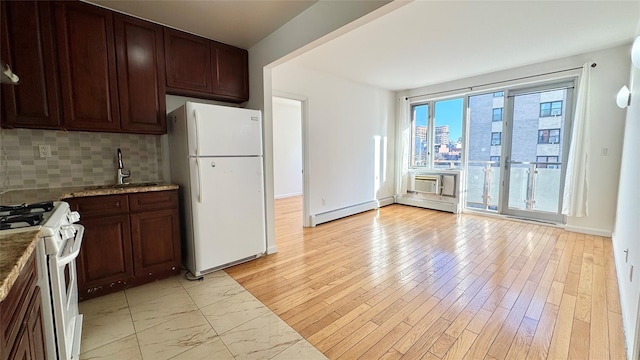 kitchen featuring sink, light hardwood / wood-style flooring, baseboard heating, white appliances, and backsplash