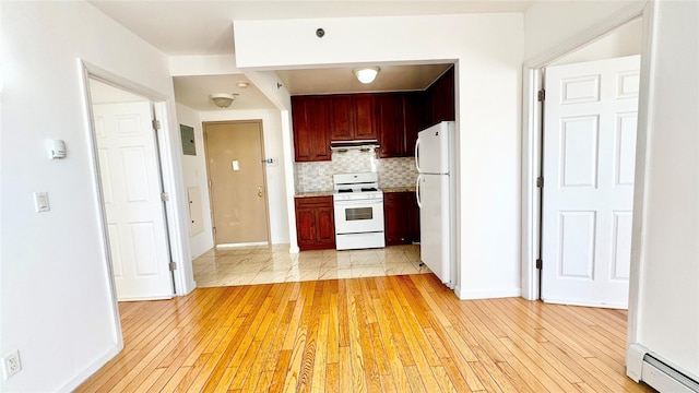 kitchen with backsplash, white appliances, light hardwood / wood-style flooring, and baseboard heating