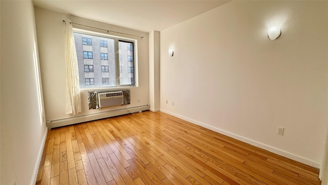 spare room with a wall mounted air conditioner, light wood-type flooring, and baseboard heating