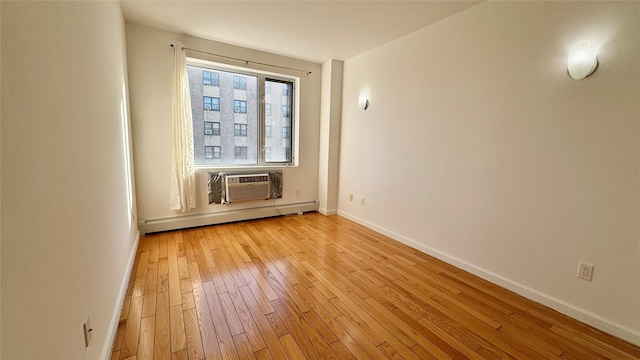 spare room with light hardwood / wood-style floors, a wall mounted AC, and baseboard heating