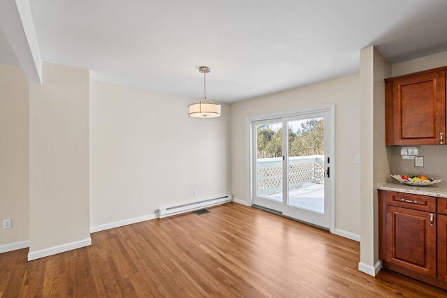 unfurnished dining area featuring light hardwood / wood-style flooring and a baseboard radiator