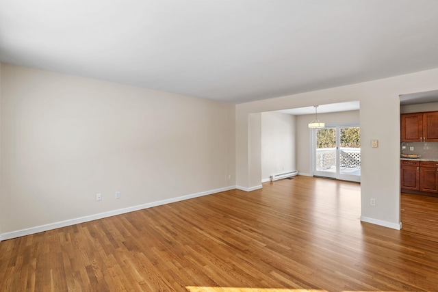 unfurnished living room with baseboard heating and light wood-type flooring