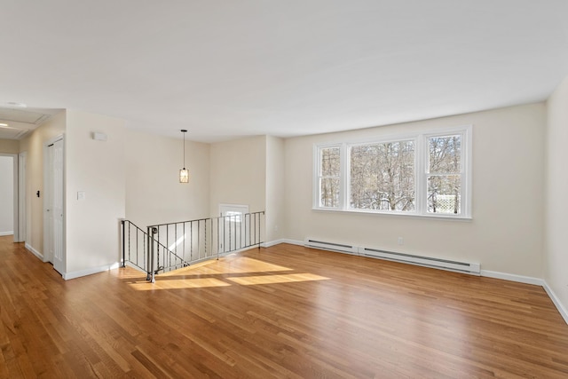 empty room with hardwood / wood-style flooring and a baseboard radiator