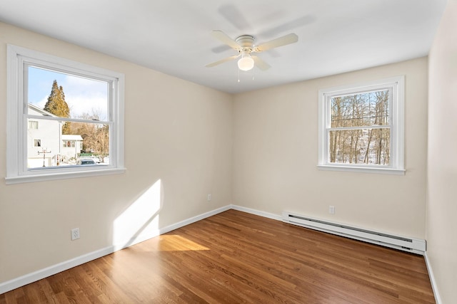 spare room with hardwood / wood-style flooring, plenty of natural light, ceiling fan, and baseboard heating